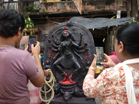 People take photos of the Durga idol outside a pottery hub ahead of the Durga Puja festival in Kolkata, India, on September 29, 2024. (