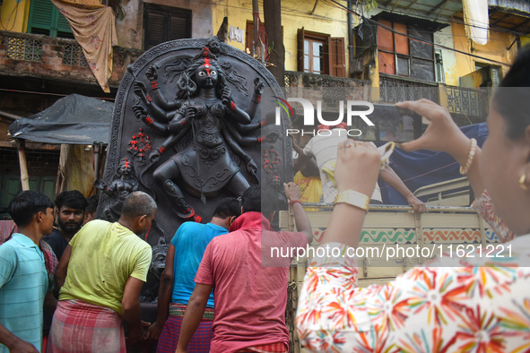 Workers load a Durga idol onto a truck for transport to a pandal, or a temporary platform, ahead of the Durga Puja festival in Kolkata, Indi...