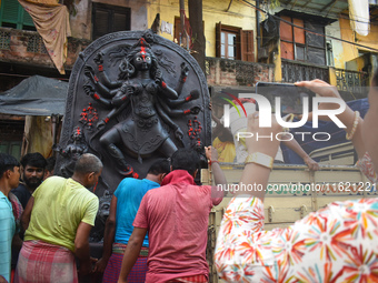 Workers load a Durga idol onto a truck for transport to a pandal, or a temporary platform, ahead of the Durga Puja festival in Kolkata, Indi...