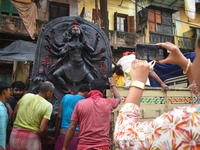 Workers load a Durga idol onto a truck for transport to a pandal, or a temporary platform, ahead of the Durga Puja festival in Kolkata, Indi...