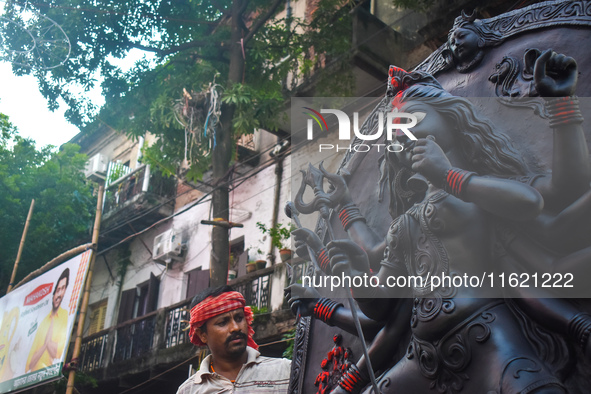 Workers load a Durga idol onto a truck for transport to a pandal, or a temporary platform, ahead of the Durga Puja festival in Kolkata, Indi...