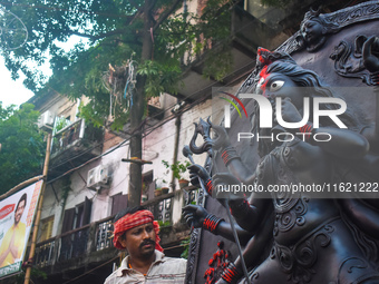 Workers load a Durga idol onto a truck for transport to a pandal, or a temporary platform, ahead of the Durga Puja festival in Kolkata, Indi...