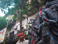 Workers load a Durga idol onto a truck for transport to a pandal, or a temporary platform, ahead of the Durga Puja festival in Kolkata, Indi...