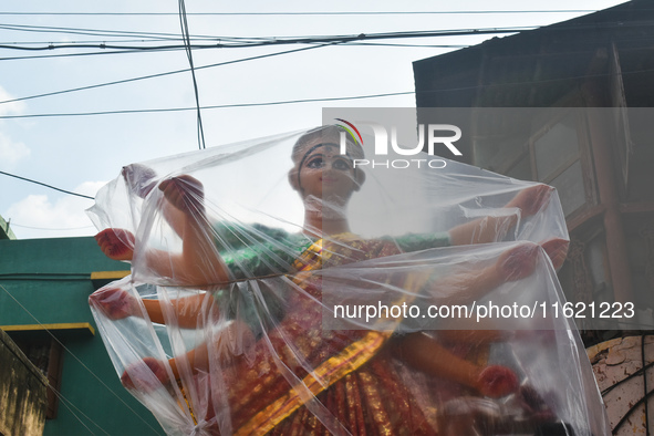 A Durga idol is covered with plastic to protect it from rain on a truck for transport to a pandal, or temporary platform, ahead of the Durga...