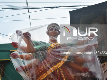 A Durga idol is covered with plastic to protect it from rain on a truck for transport to a pandal, or temporary platform, ahead of the Durga...