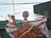 A Durga idol is covered with plastic to protect it from rain on a truck for transport to a pandal, or temporary platform, ahead of the Durga...