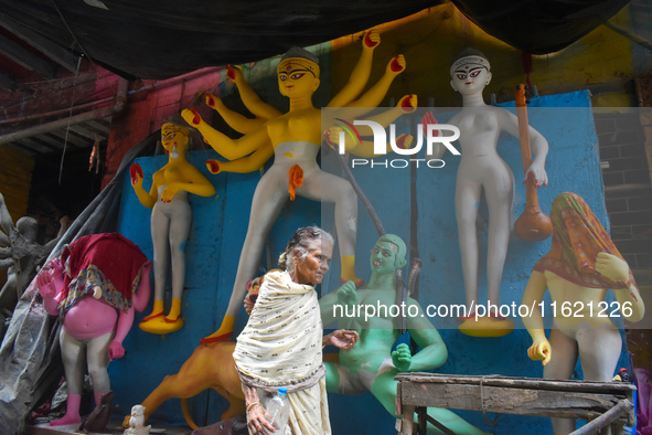 An old woman passes next to a half-made Durga idol ahead of the Durga Puja festival in Kolkata, India, on September 29, 2024. 