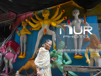 An old woman passes next to a half-made Durga idol ahead of the Durga Puja festival in Kolkata, India, on September 29, 2024. (