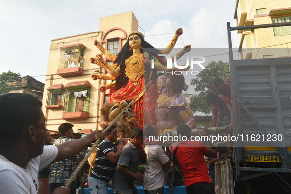 Workers load a Durga idol onto a truck for transport to a pandal, or a temporary platform, ahead of the Durga Puja festival in Kolkata, Indi...