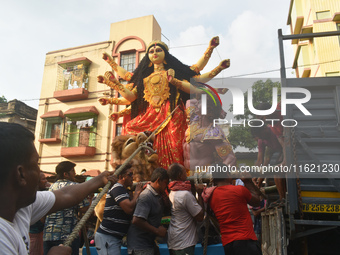 Workers load a Durga idol onto a truck for transport to a pandal, or a temporary platform, ahead of the Durga Puja festival in Kolkata, Indi...