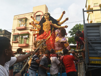 Workers load a Durga idol onto a truck for transport to a pandal, or a temporary platform, ahead of the Durga Puja festival in Kolkata, Indi...