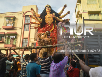 Workers load a Durga idol onto a truck for transport to a pandal, or a temporary platform, ahead of the Durga Puja festival in Kolkata, Indi...