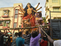 Workers load a Durga idol onto a truck for transport to a pandal, or a temporary platform, ahead of the Durga Puja festival in Kolkata, Indi...