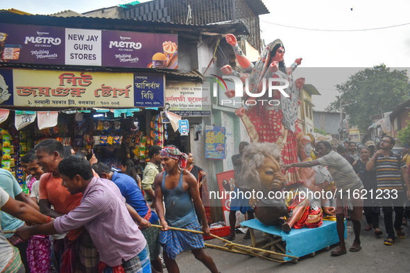 Labourers pull an idol of Durga through a street to be transported on a truck to a pandal, or a temporary platform, for the upcoming festiva...