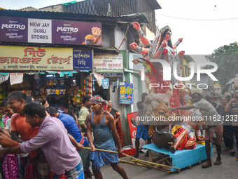 Labourers pull an idol of Durga through a street to be transported on a truck to a pandal, or a temporary platform, for the upcoming festiva...