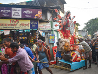 Labourers pull an idol of Durga through a street to be transported on a truck to a pandal, or a temporary platform, for the upcoming festiva...