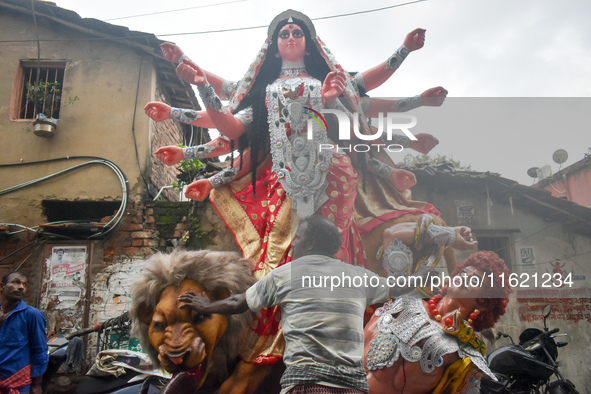 Labourers pull an idol of Durga through a street to be transported on a truck to a pandal, or a temporary platform, for the upcoming festiva...