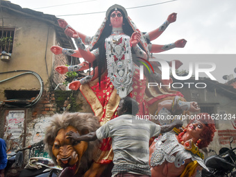 Labourers pull an idol of Durga through a street to be transported on a truck to a pandal, or a temporary platform, for the upcoming festiva...