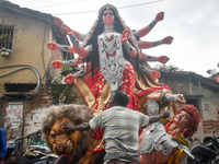 Labourers pull an idol of Durga through a street to be transported on a truck to a pandal, or a temporary platform, for the upcoming festiva...