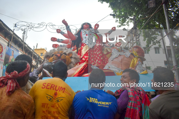 Workers load a Durga idol onto a truck for transport to a pandal, or a temporary platform, ahead of the Durga Puja festival in Kolkata, Indi...