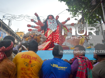 Workers load a Durga idol onto a truck for transport to a pandal, or a temporary platform, ahead of the Durga Puja festival in Kolkata, Indi...