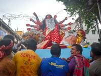 Workers load a Durga idol onto a truck for transport to a pandal, or a temporary platform, ahead of the Durga Puja festival in Kolkata, Indi...