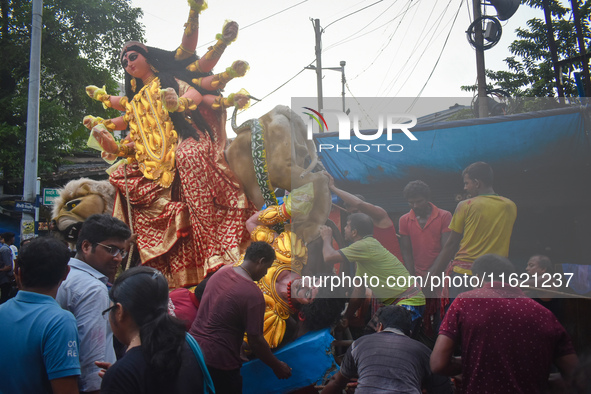 Labourers pull an idol of Durga through a street to be transported on a truck to a pandal, or a temporary platform, for the upcoming festiva...