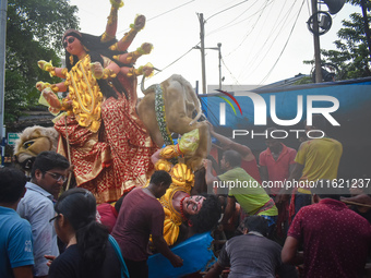 Labourers pull an idol of Durga through a street to be transported on a truck to a pandal, or a temporary platform, for the upcoming festiva...