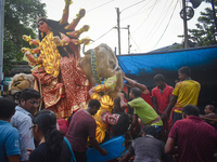 Labourers pull an idol of Durga through a street to be transported on a truck to a pandal, or a temporary platform, for the upcoming festiva...