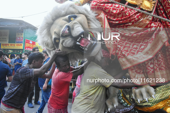 Labourers pull an idol of Durga through a street to be transported on a truck to a pandal, or a temporary platform, for the upcoming festiva...