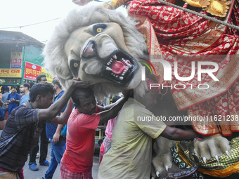 Labourers pull an idol of Durga through a street to be transported on a truck to a pandal, or a temporary platform, for the upcoming festiva...