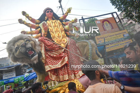 Workers load a Durga idol onto a truck for transport to a pandal, or a temporary platform, ahead of the Durga Puja festival in Kolkata, Indi...