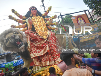 Workers load a Durga idol onto a truck for transport to a pandal, or a temporary platform, ahead of the Durga Puja festival in Kolkata, Indi...