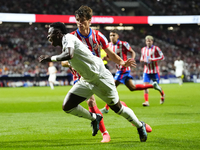 Vinicius Junior left winger of Real Madrid and Brazil and Robin Le Normand centre-back of Atletico de Madrid and Spaincompete for the ball d...