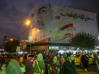 Iranian people walk under a giant banner featuring a portrait of Lebanon's Hezbollah Secretary General, Hassan Nasrallah, in downtown Tehran...