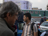 Iranian people walk under a giant banner featuring a portrait of Lebanon's Hezbollah Secretary General, Hassan Nasrallah, in downtown Tehran...