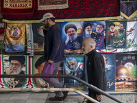 Iranian men walk past posters featuring portraits of Lebanon's Hezbollah Secretary General, Hassan Nasrallah, and Iranian commander of the I...