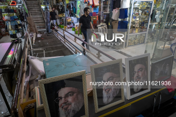 An Iranian man walks past framed portraits of Lebanon's Hezbollah Secretary General, Hassan Nasrallah, who was killed in an Israeli air stri...