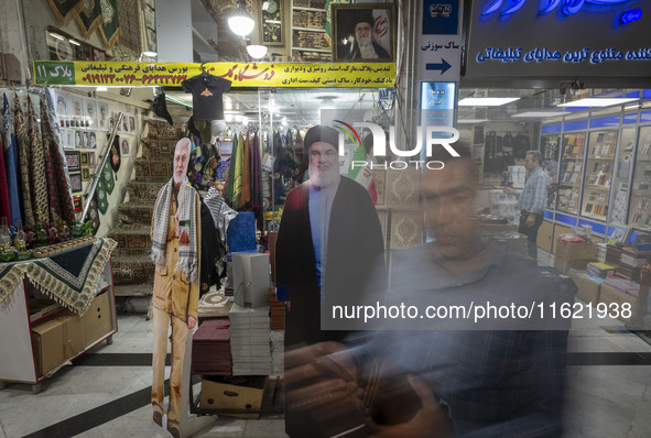 An Iranian man walks past an effigy of Lebanon's Hezbollah Secretary General, Hassan Nasrallah, who was killed in an Israeli air strike in a...