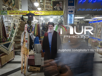 An Iranian man walks past an effigy of Lebanon's Hezbollah Secretary General, Hassan Nasrallah, who was killed in an Israeli air strike in a...