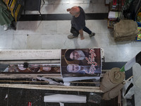 An Iranian man walks past a poster featuring portraits of Lebanon's Hezbollah Secretary General, Hassan Nasrallah, who was killed in an Isra...