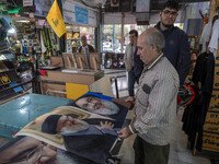 An Iranian man looks at portraits of Lebanon's Hezbollah Secretary General, Hassan Nasrallah, who is killed in an Israeli air strike in a su...