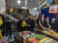 An Iranian man holds a flag of Lebanon's Hezbollah while shopping at a war toys and religious accessory shopping mall in downtown Tehran, Ir...