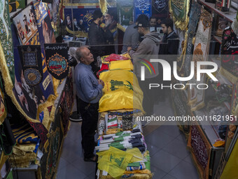 An elderly man stands next to a flag of Lebanon's Hezbollah at a flag shop in a war toys and religious accessory shopping mall in downtown T...