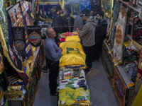 An elderly man stands next to a flag of Lebanon's Hezbollah at a flag shop in a war toys and religious accessory shopping mall in downtown T...