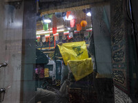 A worker holds a flag of Lebanon's Hezbollah at a flag and banner shop at a war toys and religious accessory shopping mall in downtown Tehra...