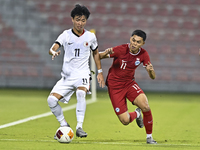 Fairuz Fazli (R) of Singapore battles for the ball with Ho Tung Lam (L) of Hong Kong, China, during the 2025 AFC U20 Asian Cup Qualifiers Gr...