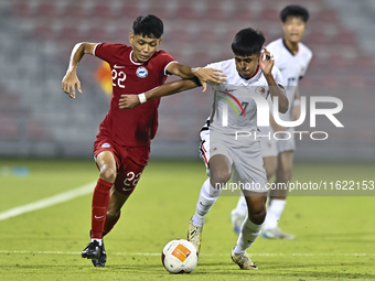 Muhammad Hud Bin Muhammad Ismail (L) of Singapore battles for the ball with Anthony Francis Pinto (R) of Hong Kong, China, during the 2025 A...