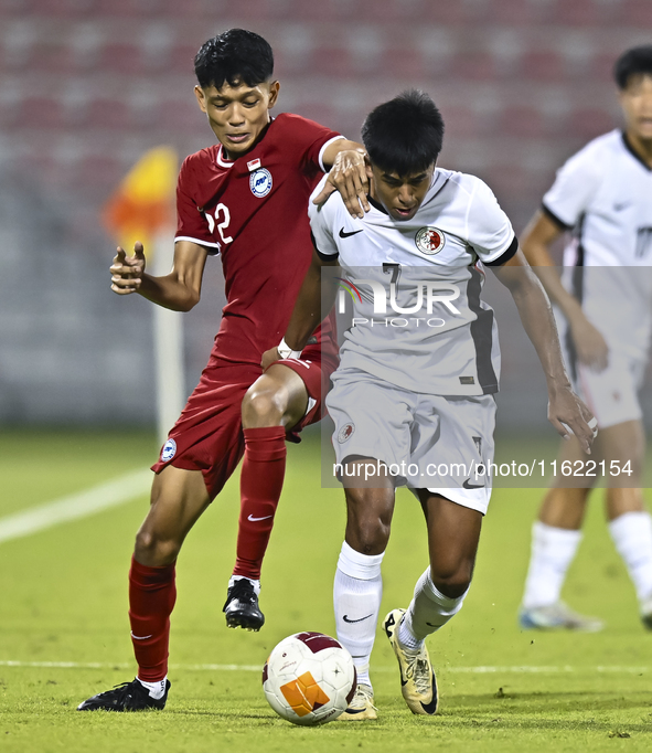 Muhammad Hud Bin Muhammad Ismail (L) of Singapore battles for the ball with Anthony Francis Pinto (R) of Hong Kong, China, during the 2025 A...