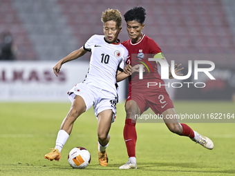 Raoul Suhaimi (R) of Singapore battles for the ball with Chiu Ching Yu Sergio (L) of Hong Kong, China, during the 2025 AFC U20 Asian Cup Qua...